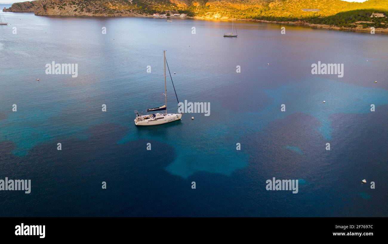 Vista aerea del drone di una barca a vela ancorata in una baia dell'isola di Cabrera nell'arcipelago delle Isole Baleari, Spagna Foto Stock