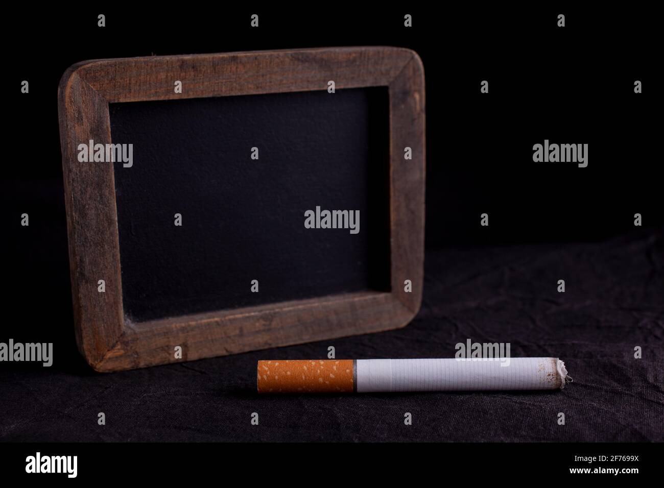 Sigarette e mini asse di gesso su sfondo scuro. Copia spazio. Mondo no tabacco giorno Foto Stock
