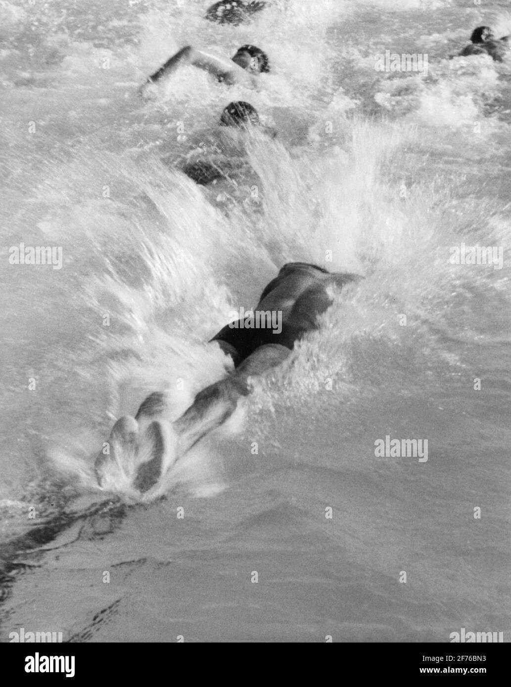Racer si tuffa in una piscina mentre fa giri in un relè di nuoto. Foto Stock