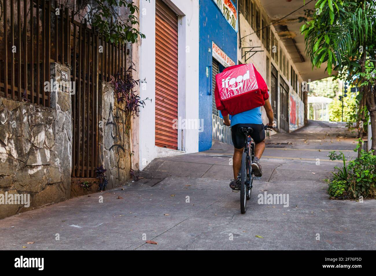 Un pilota di biciclette ifood che si sposta su una collina a Belo Horizonte, Brasile. Foto Stock