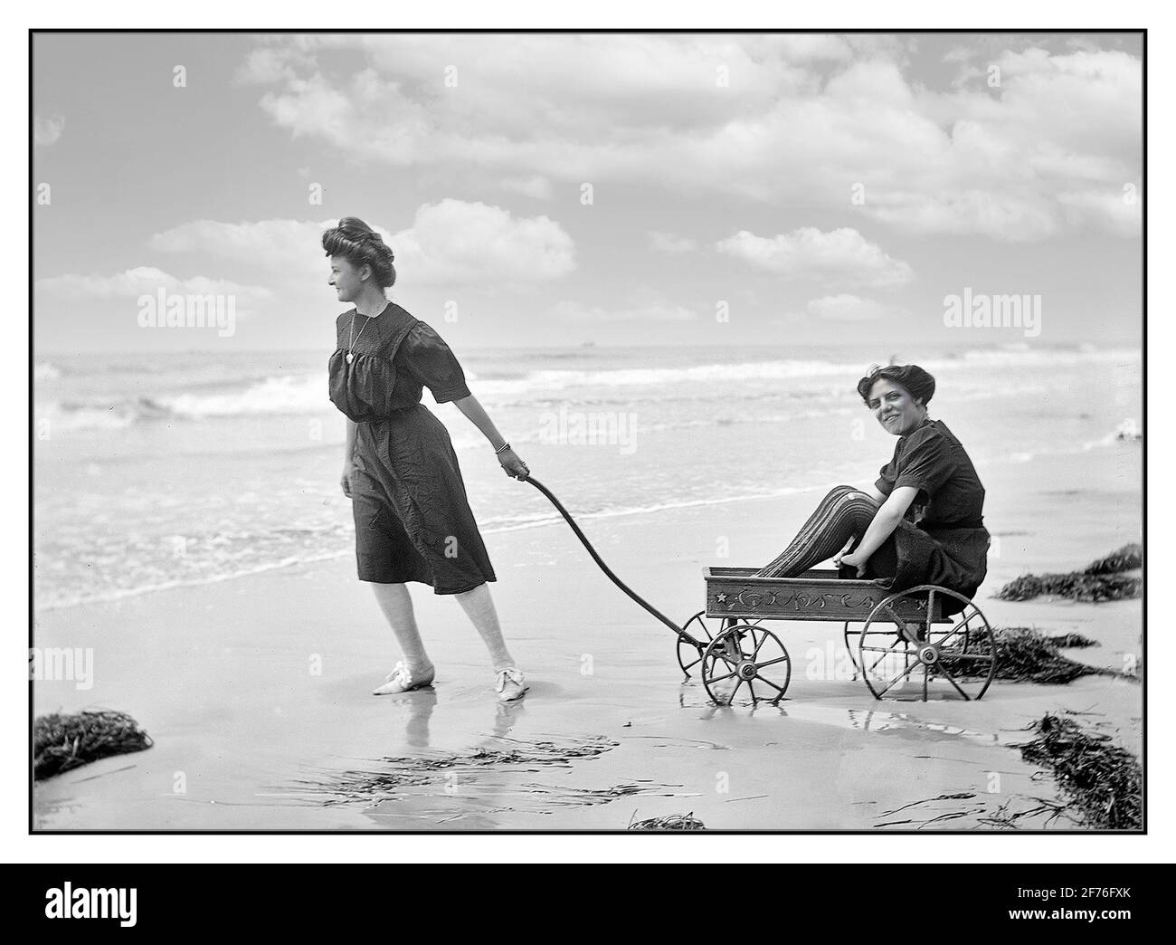 Belles da bagno d'epoca con un modesto abbigliamento da spiaggia vittoriano che si diverge a giocare sulla spiaggia a Atlantic City, NJ circa 1905 USA America americana stile di vita Moda 1900 Foto Stock