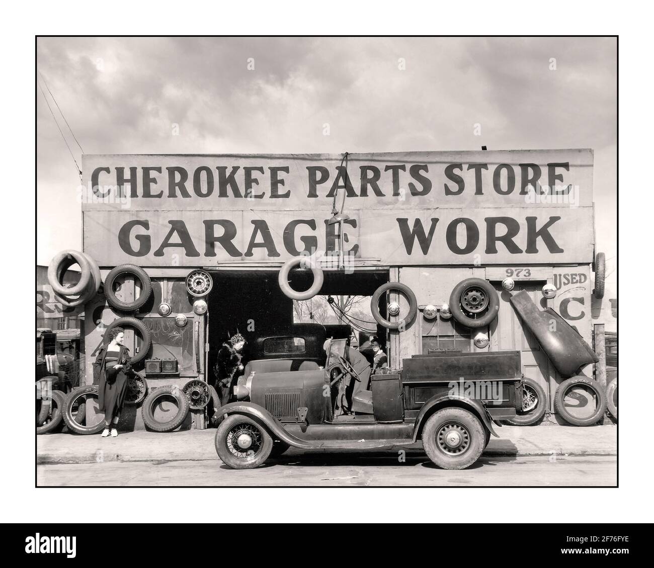 Auto auto 1920's Cherokee Parts Store servizio di riparazione officina Struttura con Ford Model UN pick-up con cabina aperta in primo piano USA 1900's Lifestyle moda post WW1 lavoro occupazione Foto Stock