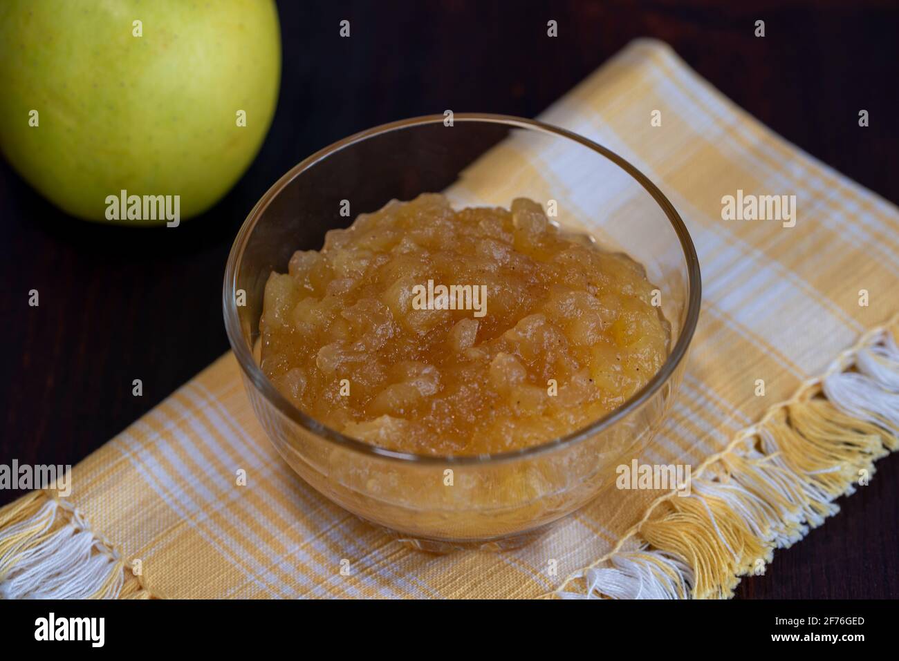 salsa di mele in un bicchiere di vetro su una superficie di legno Foto Stock