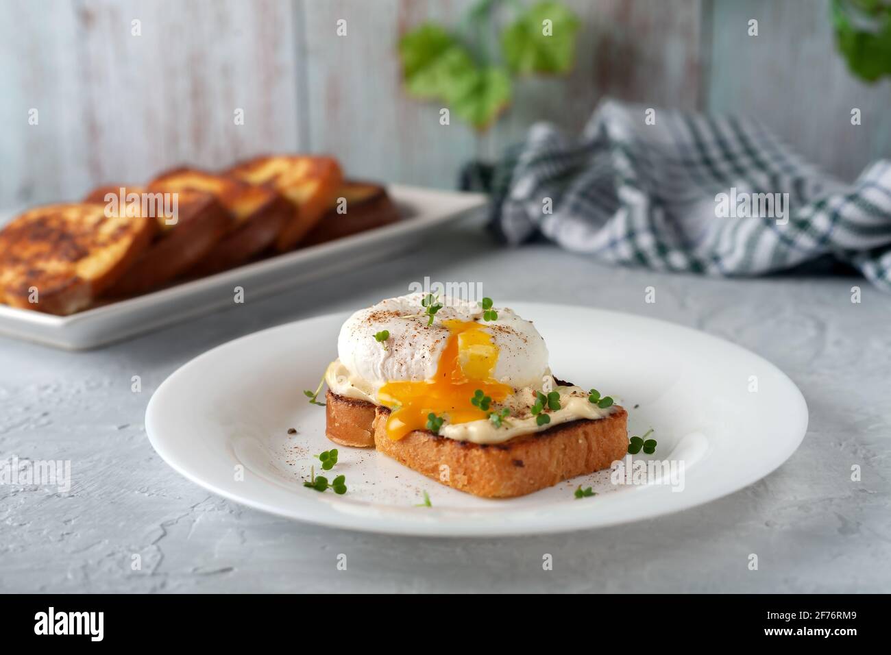 Uovo in camicia con maionese e micro-verdi. Colazione deliziosa. Cibo sano Foto Stock