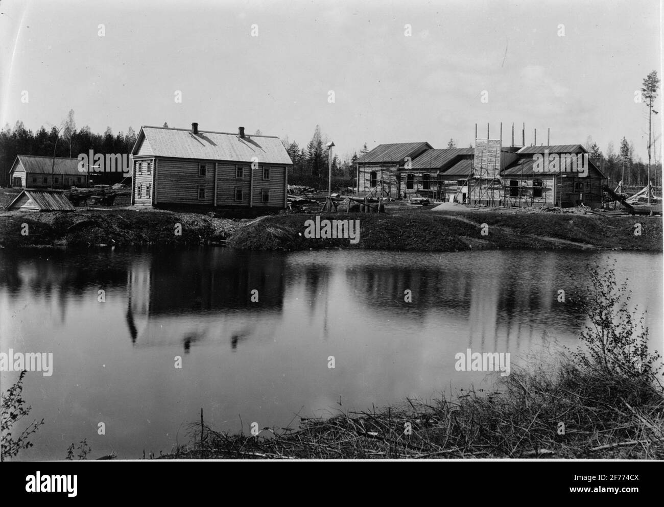 Altoforno Dodino. Il lago artificiale. Dietro, da sinistra: Smedjan e falegname, ufficio e ingegnere Larsson casa e altoforno. Foto Stock