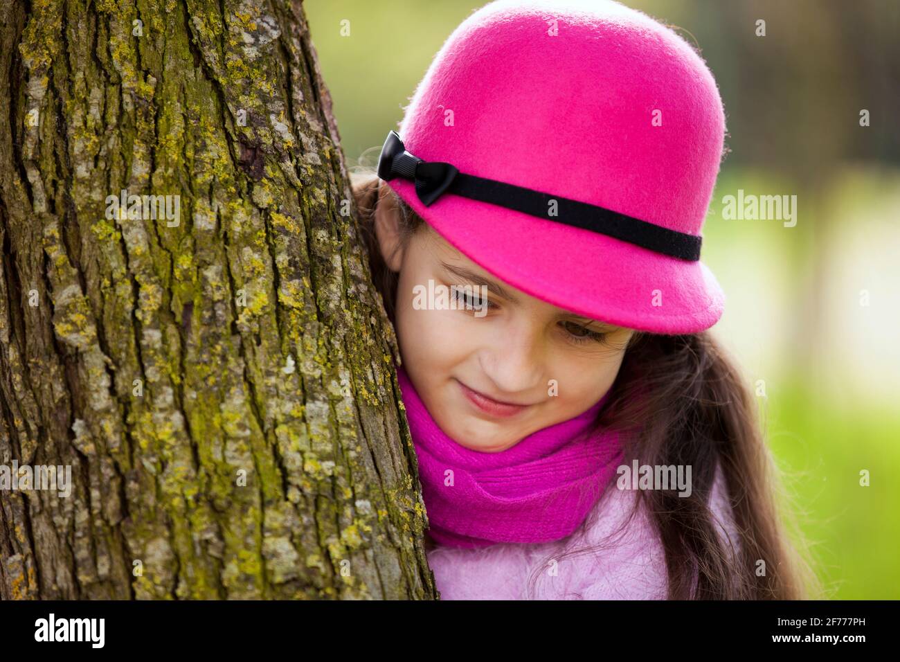 Bambino che sbirciava dietro un albero Foto Stock