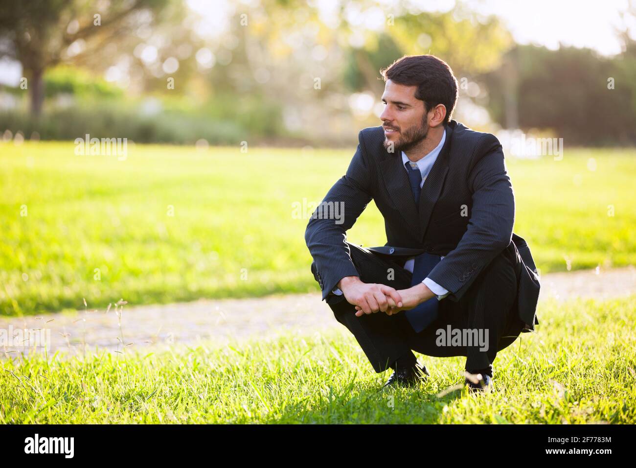 Uomo d'affari che gode l'odore dell'erba Foto Stock