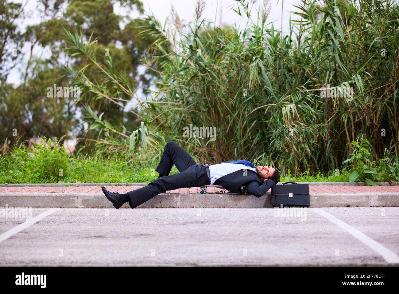 Uomo d'affari che riposa con il suo skateboard Foto Stock