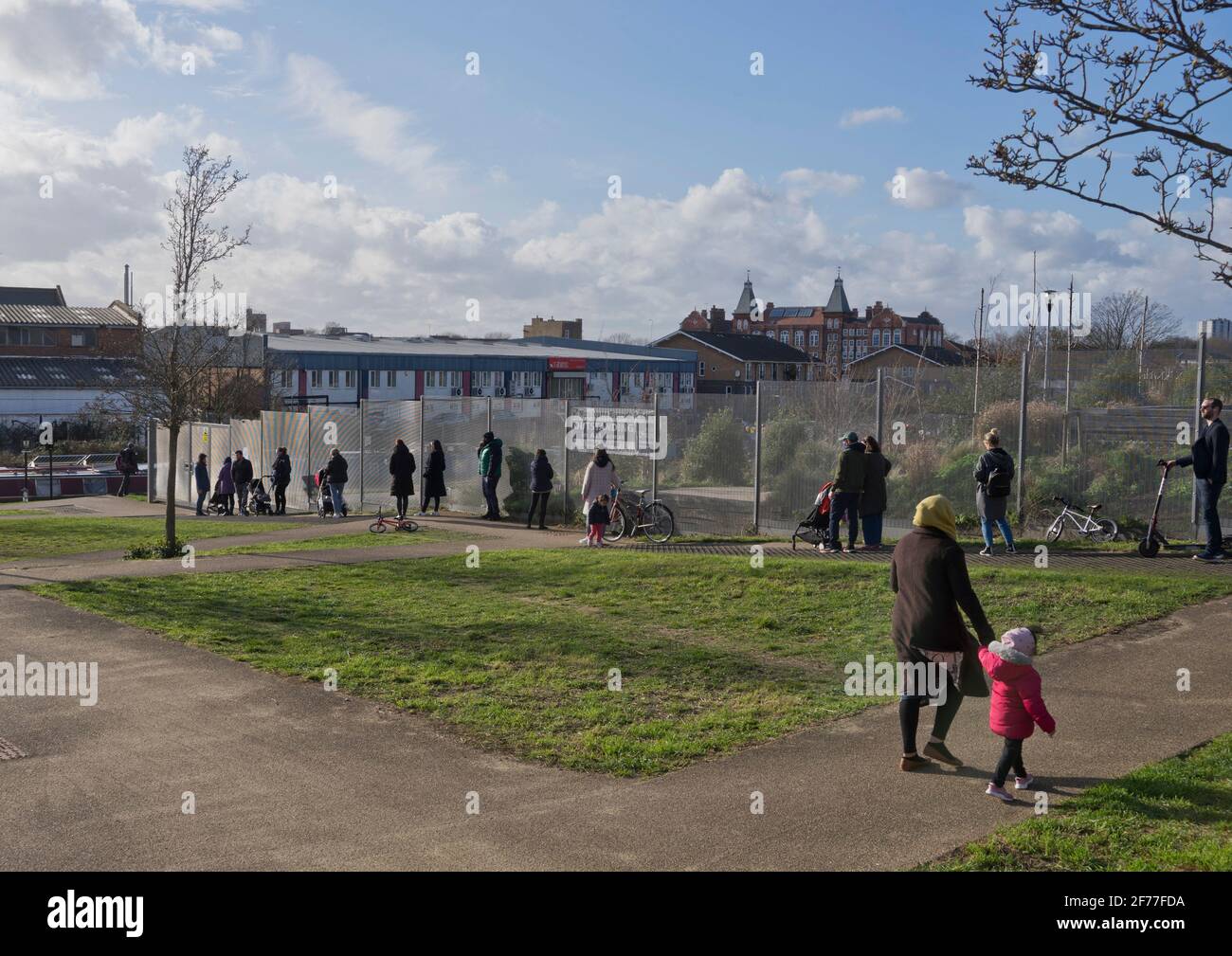 I genitori in linea con la distanza sociale per prelevare i loro figli da una scuola primaria che ha riaperto dopo tre mesi di chiusura a causa di blocco per prevenire la diffusione della pandemia di Coronavirus a Londra, Inghilterra, Regno Unito. Foto Stock