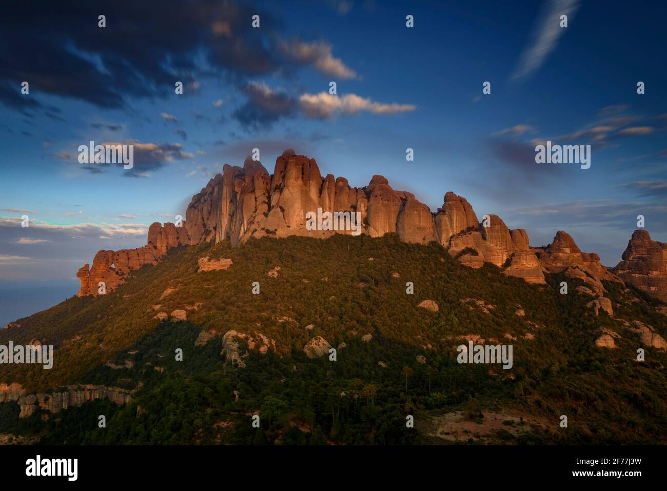 Montserrat West Face (chiamato Serrat de la Portella) e Roca Foradada, al tramonto, visto da Sant Pau Vell de la Guàrdia (Barcellona, Catalogna, Spagna) Foto Stock