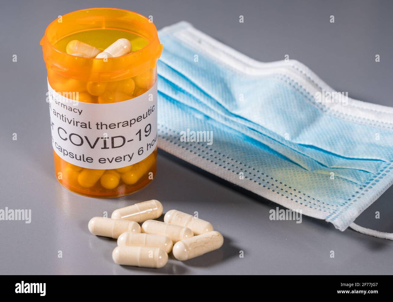 Flacone e capsule con prescrizione che illustrano le prove di trattamento antivirale orale Per il virus SARS-COV-2 o Covid-19 Foto Stock