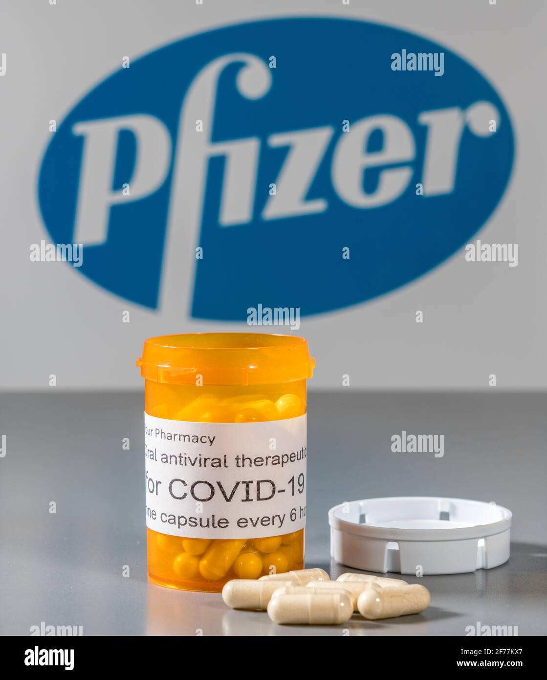 Morgantown, WV - 5 aprile 2021: Flacone e capsule da prescrizione illustra le prove Pfizer di trattamento antivirale orale per il virus SARS-COV-2 o Covid-19 Foto Stock
