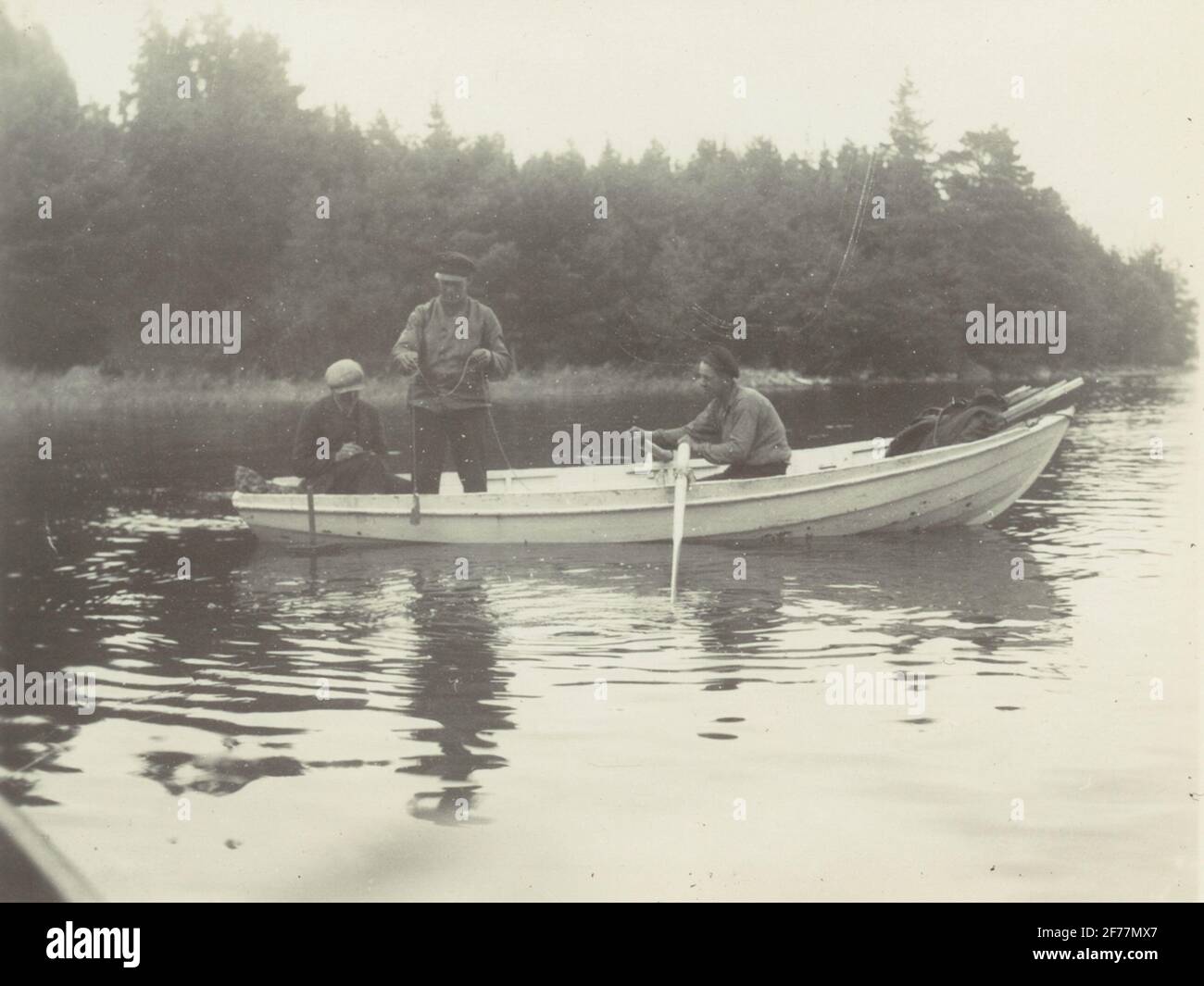 Tre uomini in una boat.Finnvikskabeln. Misurazione e cuscinetto a Hat Strait. Dall'album, il casco da lavoro a cavo (casco) - Norrtälje - Finnviken si è esibito durante l'estate del 1928. Foto Stock