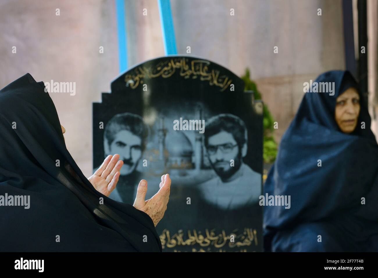 Iran, Teheran, Cimitero dei martiri della guerra Iran-Irak, Donna in preghiera Foto Stock