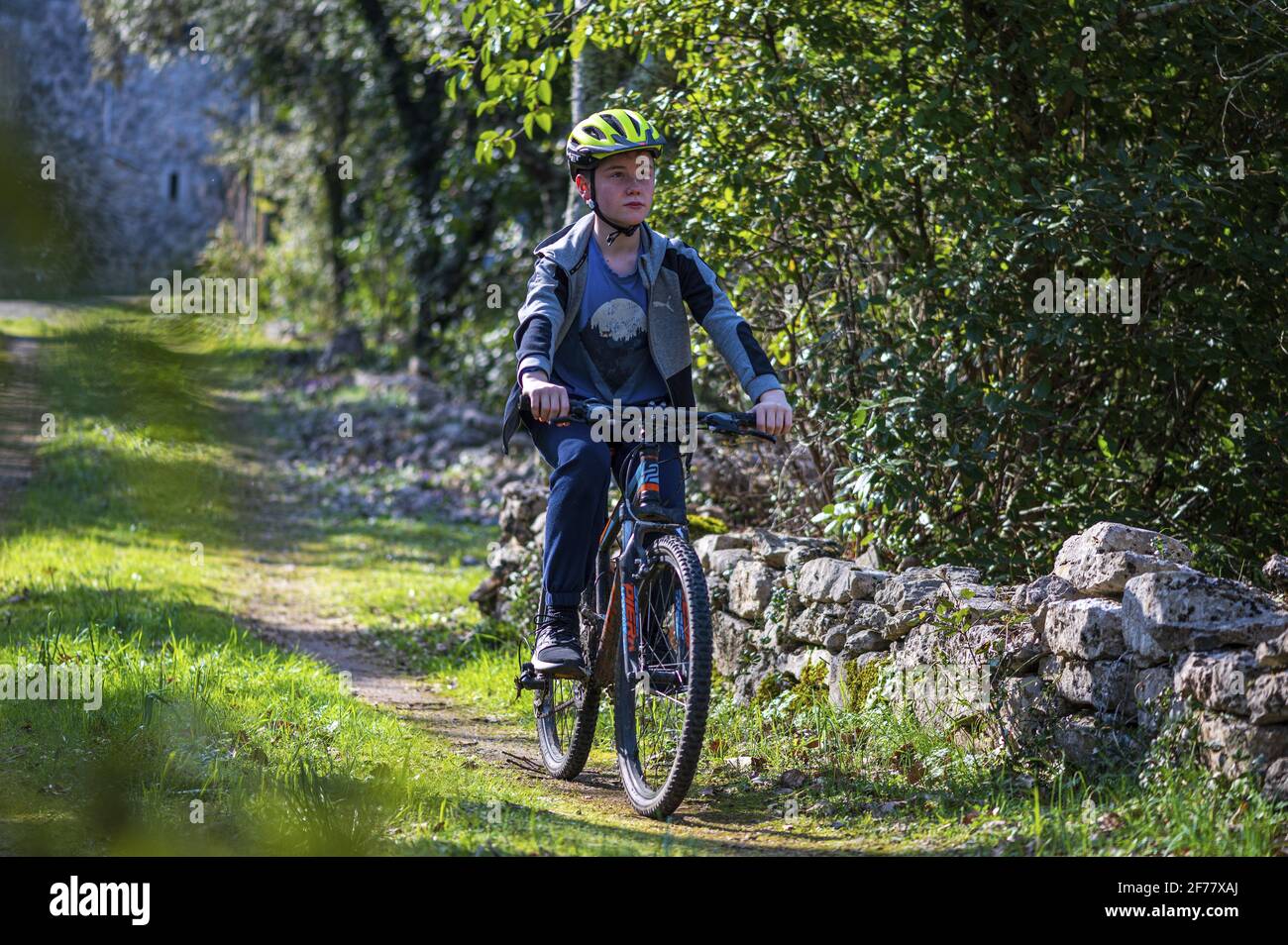 Francia, Ardeche, Gorges de l'Ardèche, villaggio di Labeaume, ragazzo che cavalca la sua bicicletta (MR sì) Foto Stock