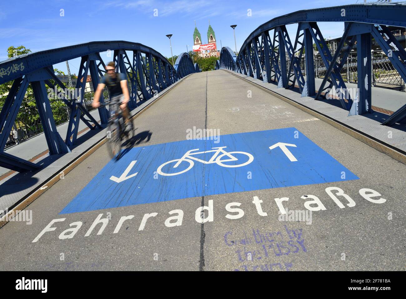 Germania, Baden Wurttemberg, Freiburg im Breisgau, ciclista sul ponte blu (ponte wilwili) e il Sacro cuore della Chiesa di Gesù (Herz Jesu kirche) Foto Stock