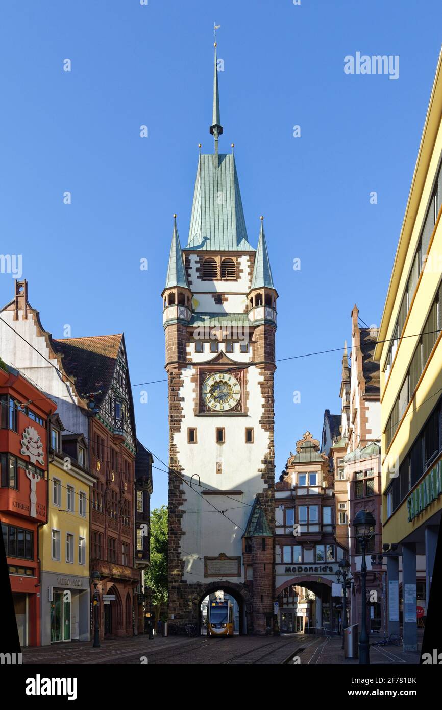 Germania, Baden Wurttemberg, Freiburg im Breisgau, tram sulla strada Kaiser Joseph Strasse e il Martinstor una delle porte originali della città Foto Stock