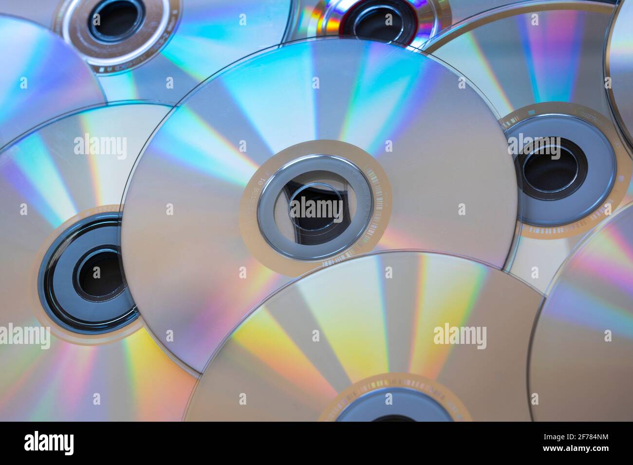 Una pila di CD (Compact Disc) con il lato argento rivolto verso l'alto (dal basso verso l'alto / capovolto). I CD sono un formato di memorizzazione dei dati su disco ottico digitale obsoleto Foto Stock