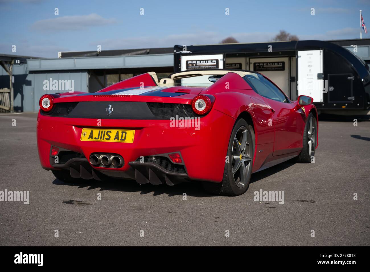 Una supercar Ferrari 458 Spider in classico rosso parcheggiata in una giornata di pista. Foto Stock