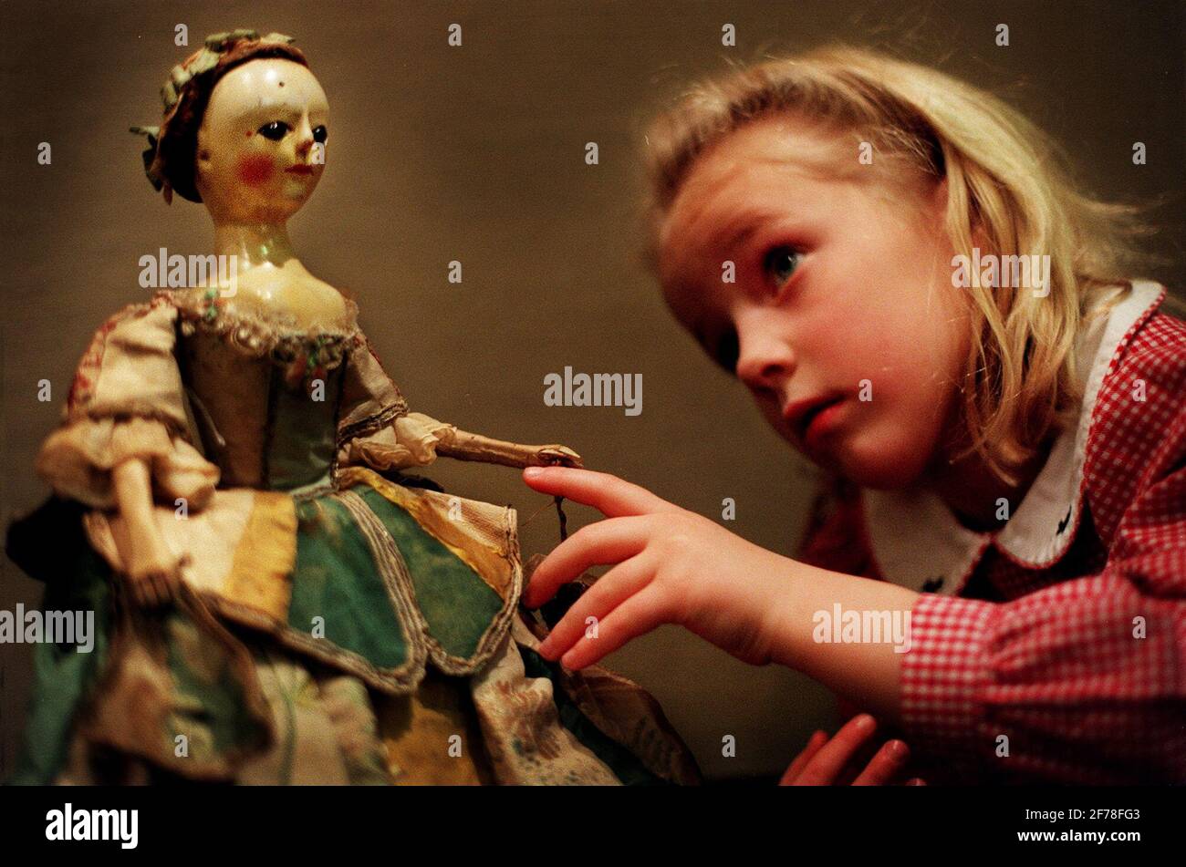 Katie Macpoarson di 5 anni ispeziona una bambola di legno di rae George i,  una bambola inglese fatta intorno a 1720, che si prevede di recuperare  ¿7,000-¿10,000 all'asta 'due secoli di bambole