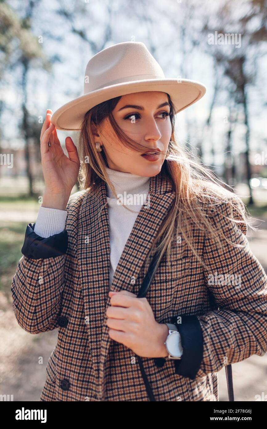 Bella donna che indossa blazer elegante, cappello che tiene borsa nel  parco. Primavera femminile outfit alla moda. Primo piano Foto stock - Alamy