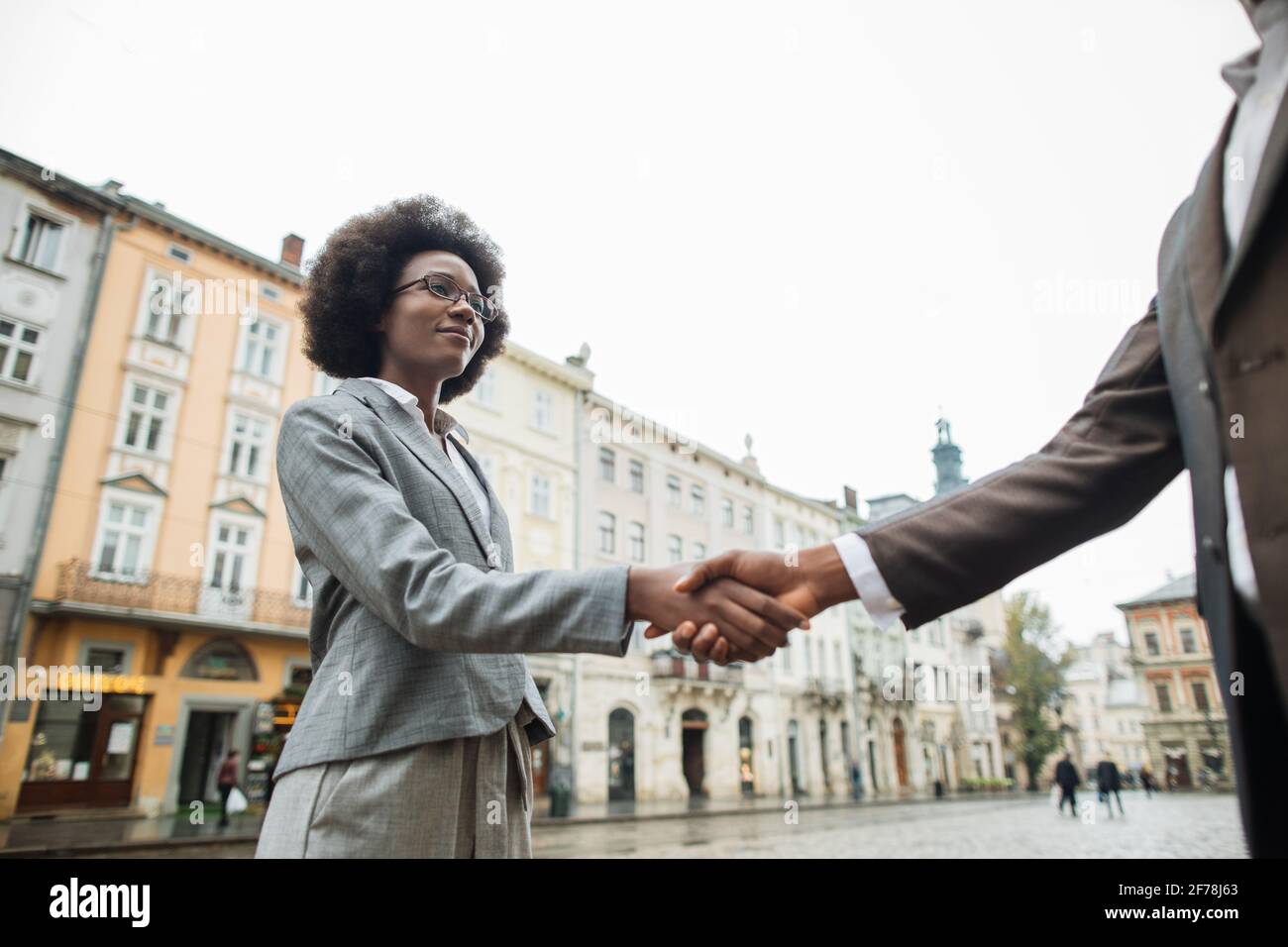 Colleghi africani di successo in abito formale si salutano l'un l'altro con la mano scuotendo sulla strada. Concetto di cooperazione e partenariato. Foto Stock