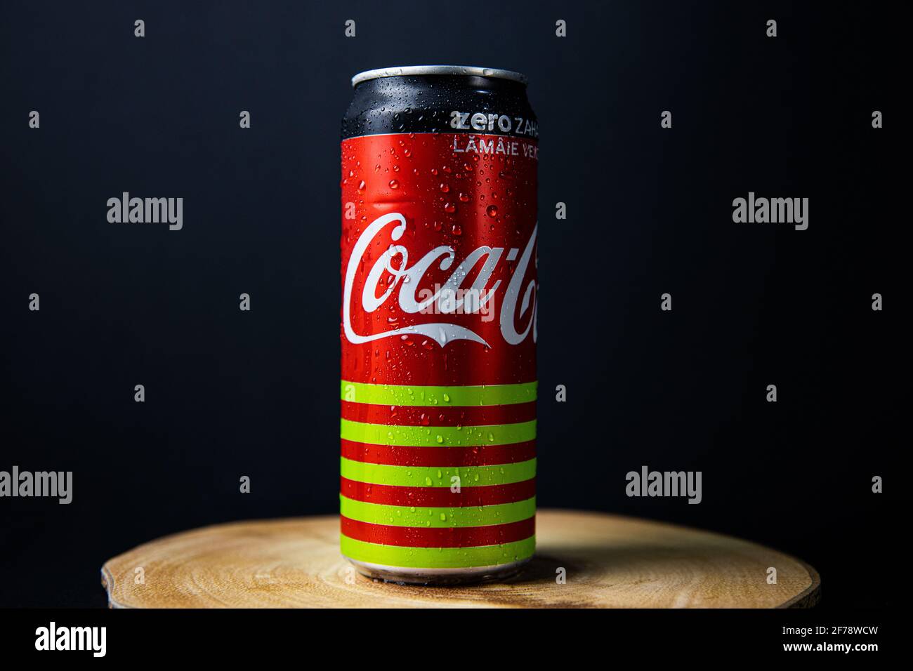 Galati, Romania, 13 aprile 2021 : lattina di Coca Cola posta su un piatto di legno in una bella luce con uno sfondo nero-bluastro Foto Stock