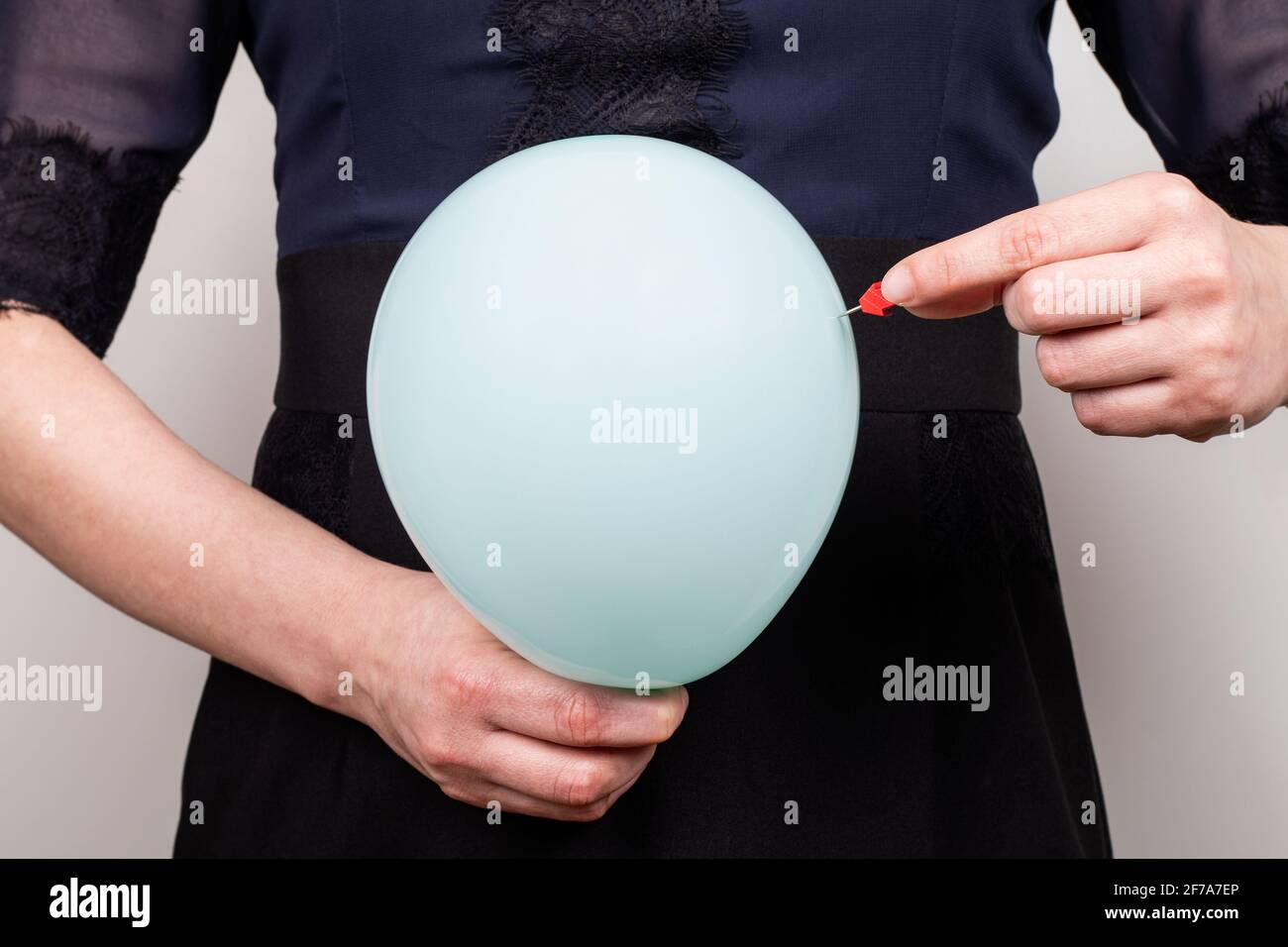 Stomaco gonfiato. Dolore e problemi di salute. Donna con palloncino blu e ago. Foto Stock