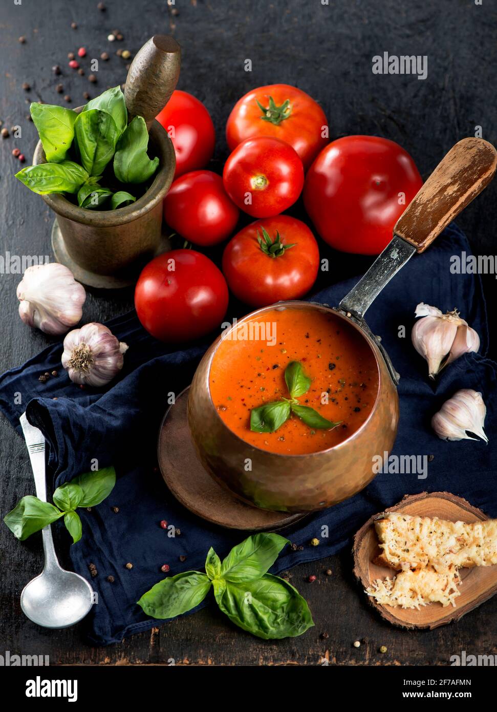 Zuppa tradizionale italiana di pomodoro gazpacho con basilico. Sfondo scuro Foto Stock