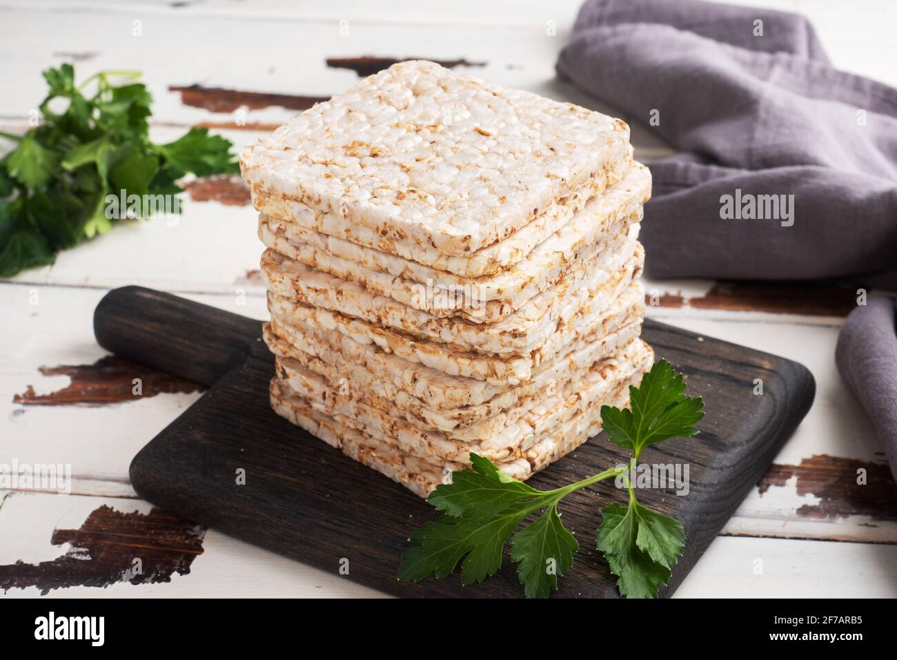 Snack sano Croccato croccante croccante con foglie di prezzemolo fresco. Sfondo in legno, spazio copia Foto Stock