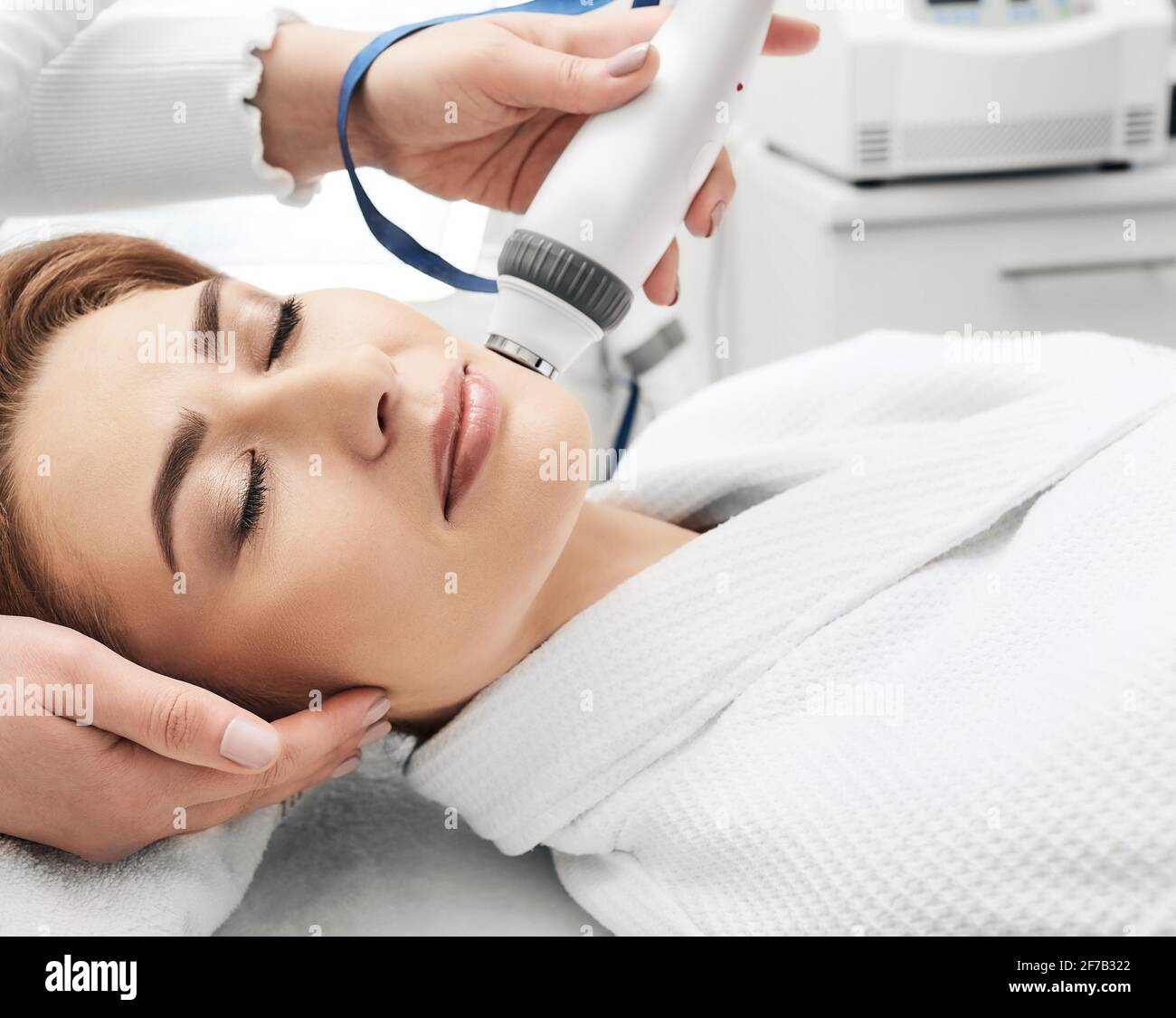 Donna adulta durante rf-lifting faccia pelle stretta con la sua estetista in un salone di bellezza, primo piano Foto Stock