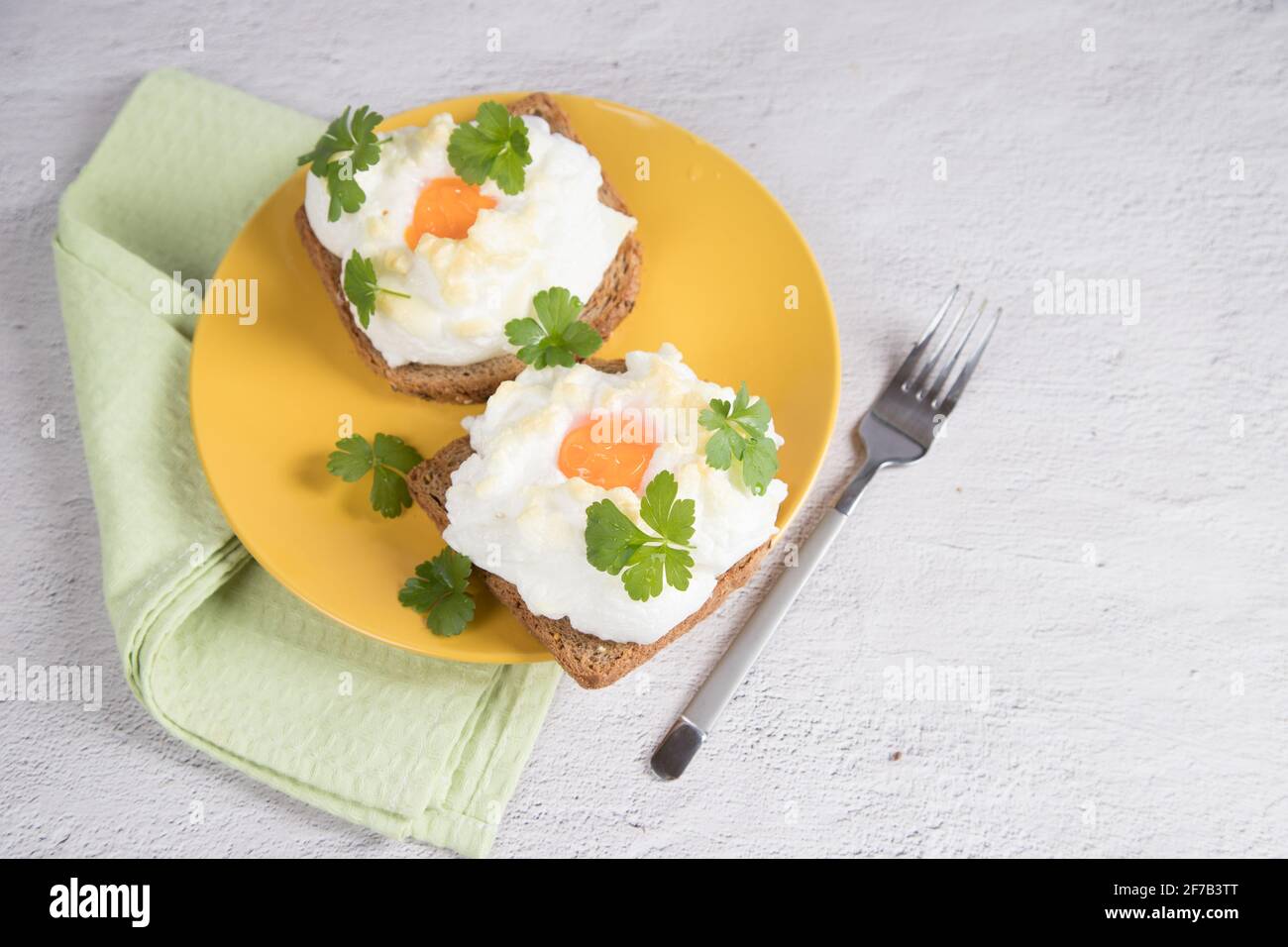 Vista dall'alto di un piatto con una colazione dietetica di toast al forno con uova sbattute. Foto Stock