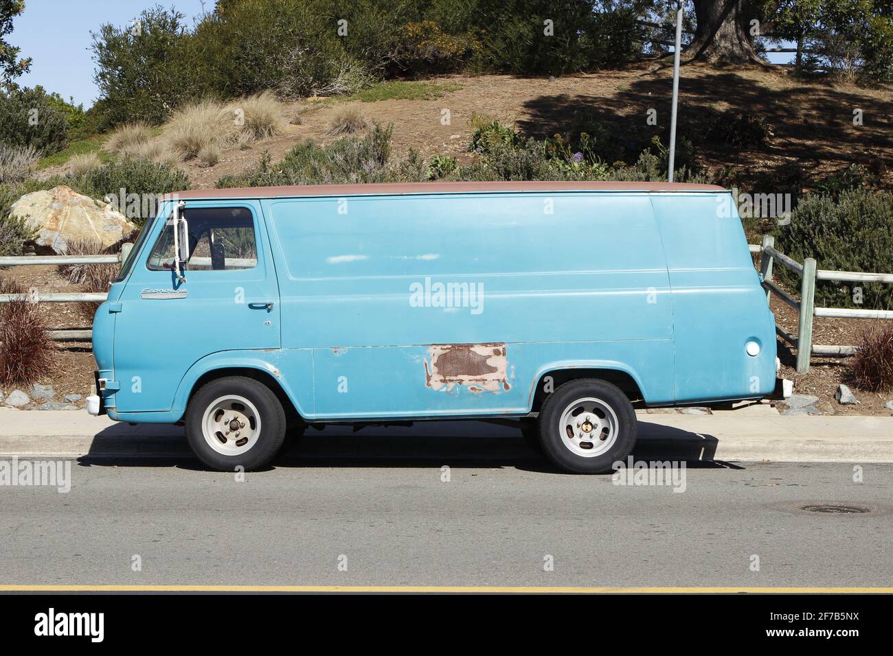 Old Blue van parcheggiato in strada con ruggine spot Foto Stock