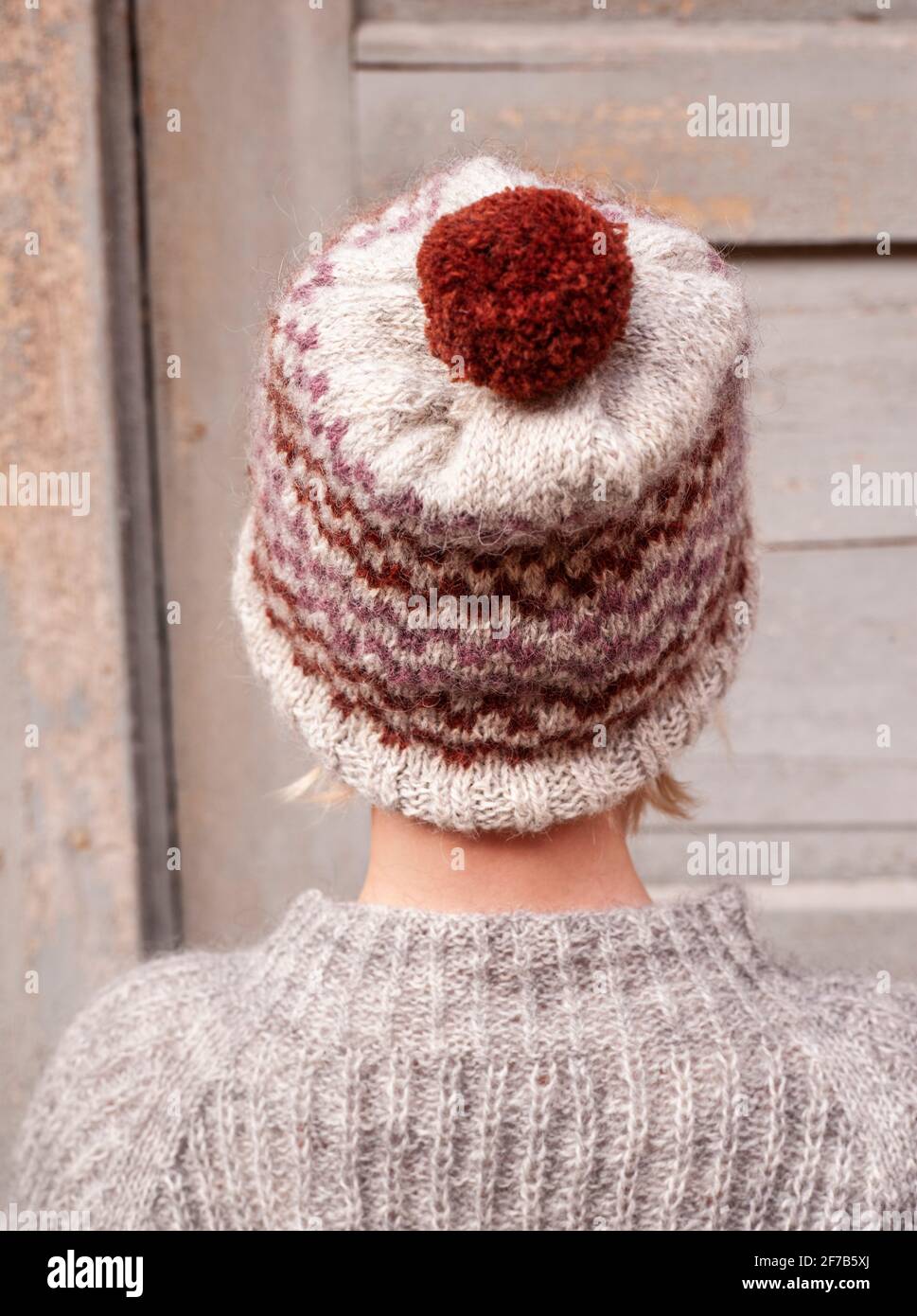 Vista posteriore del bambino che indossa un cappello a maglia con pompon Foto Stock