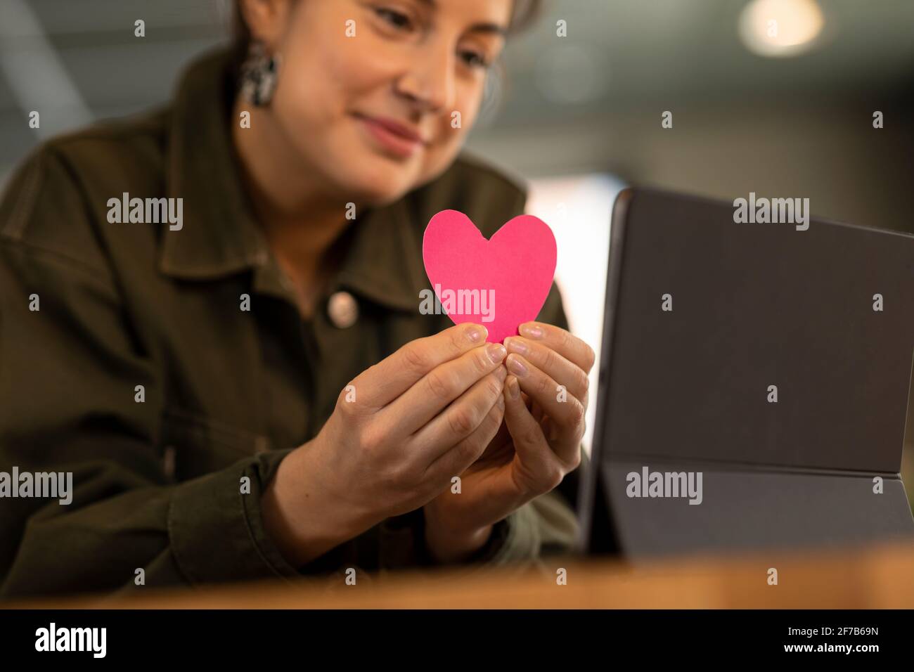 Mani della donna che tengono il cuore di carta Foto Stock