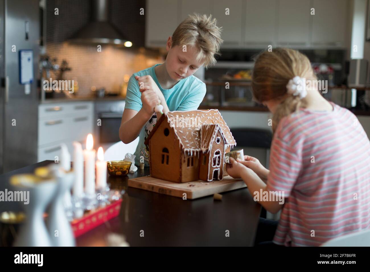 I bambini preparano la casa del pan di zenzero in cucina Foto Stock