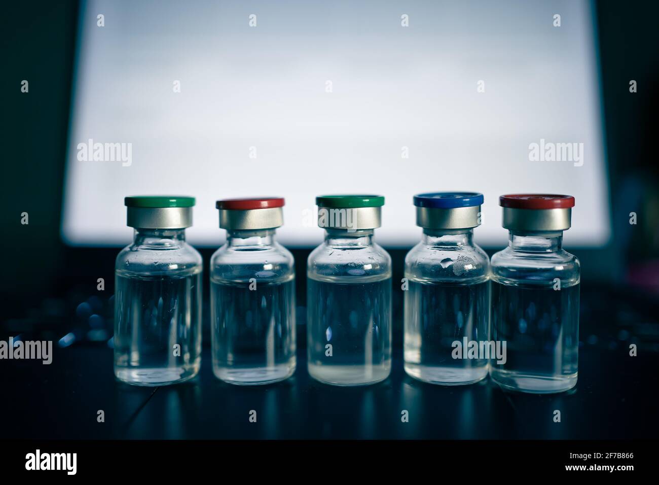 fiale di vaccino con coperchi colorati Foto Stock