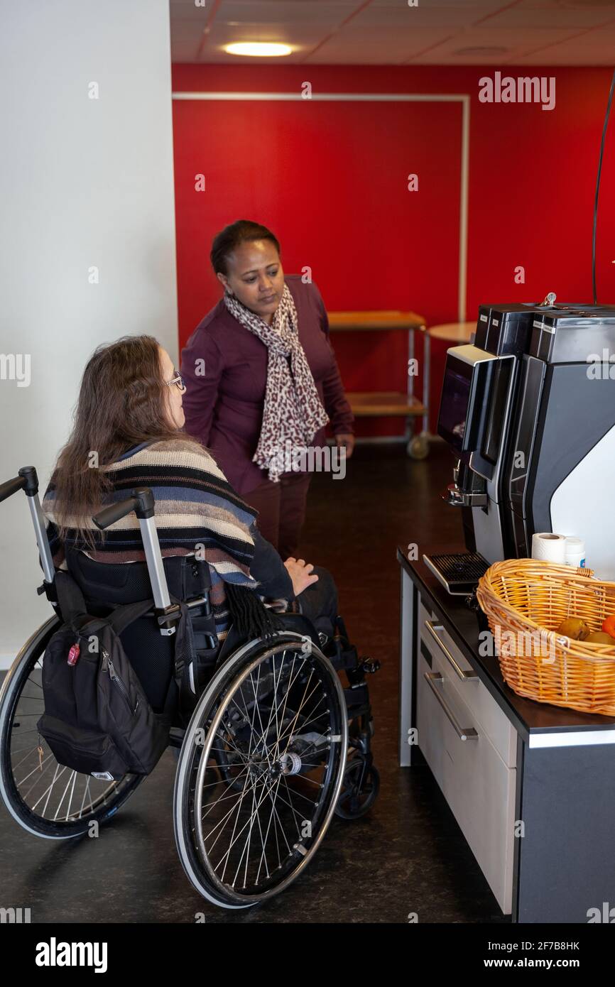 Donna disabile con collega in mensa ufficio Foto Stock