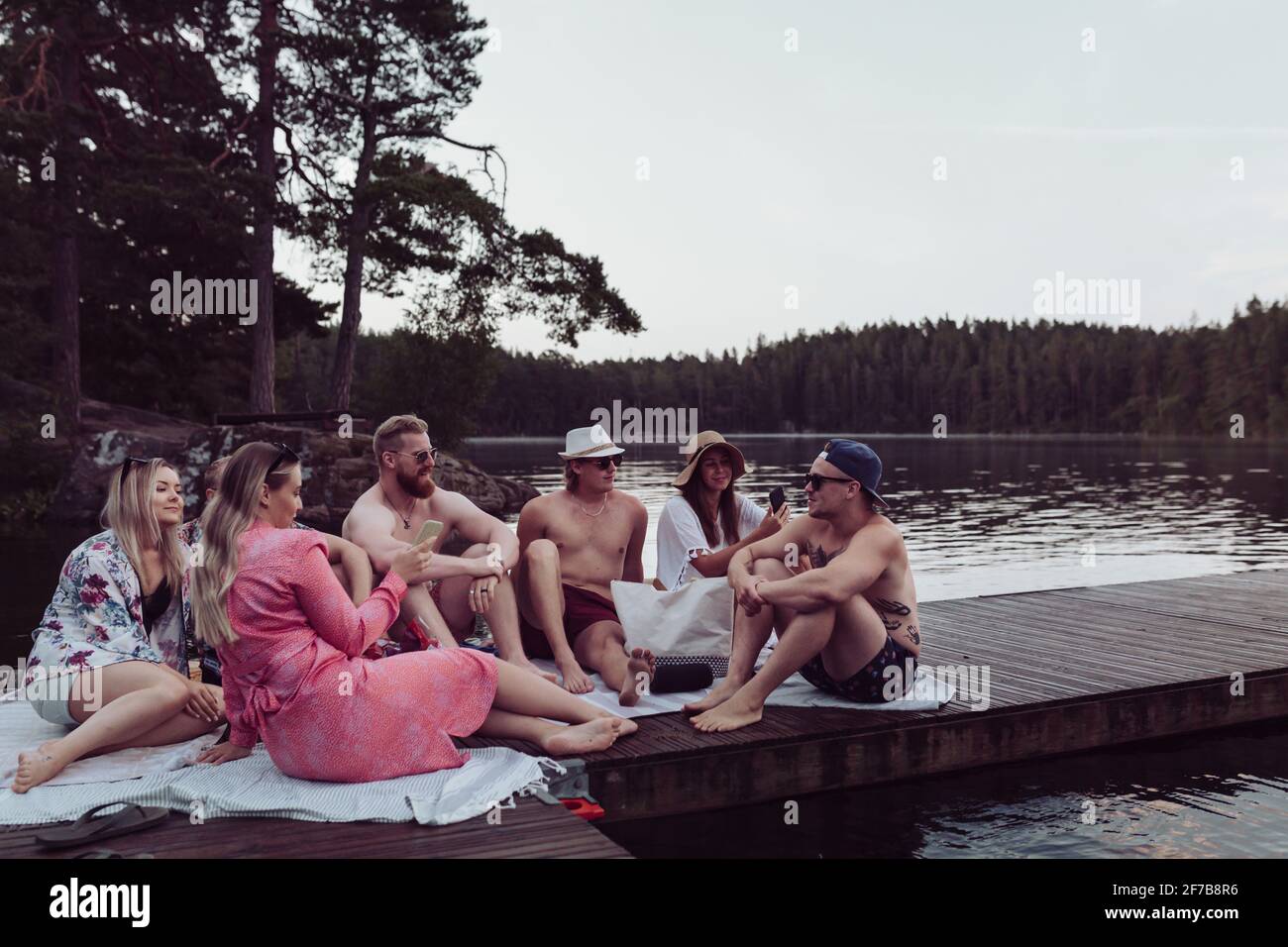 Gli amici si rilassano sul lago Foto Stock
