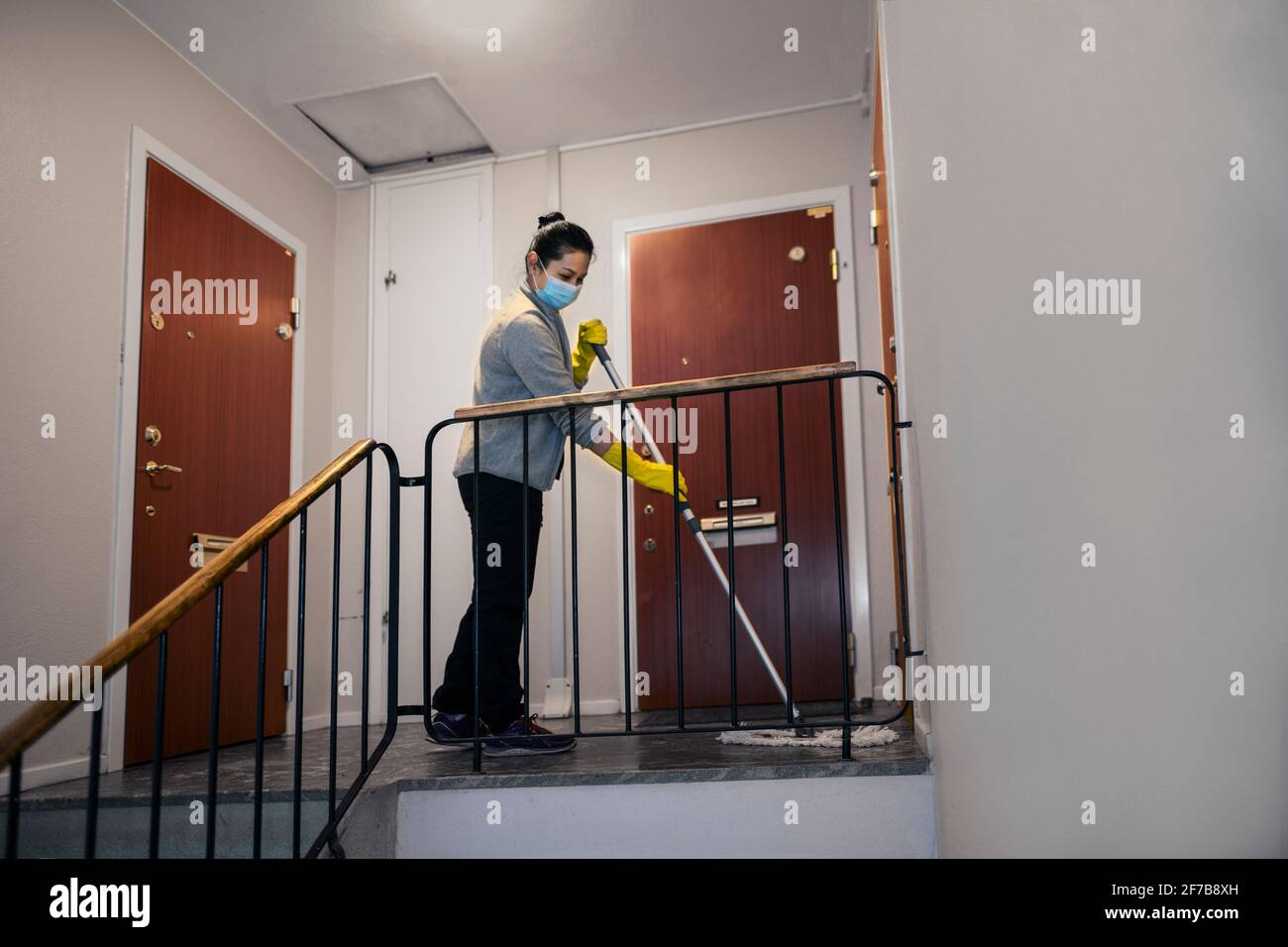Donna mopping scala Foto Stock