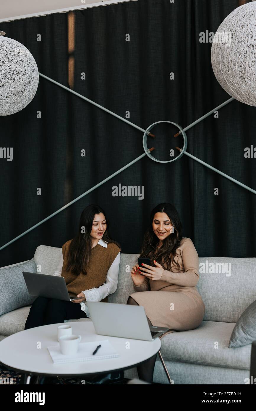 Donne che si siedono sul divano Foto Stock