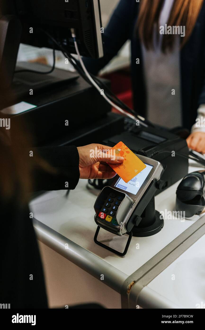 Donna pagando con carta di credito in un negozio Foto Stock