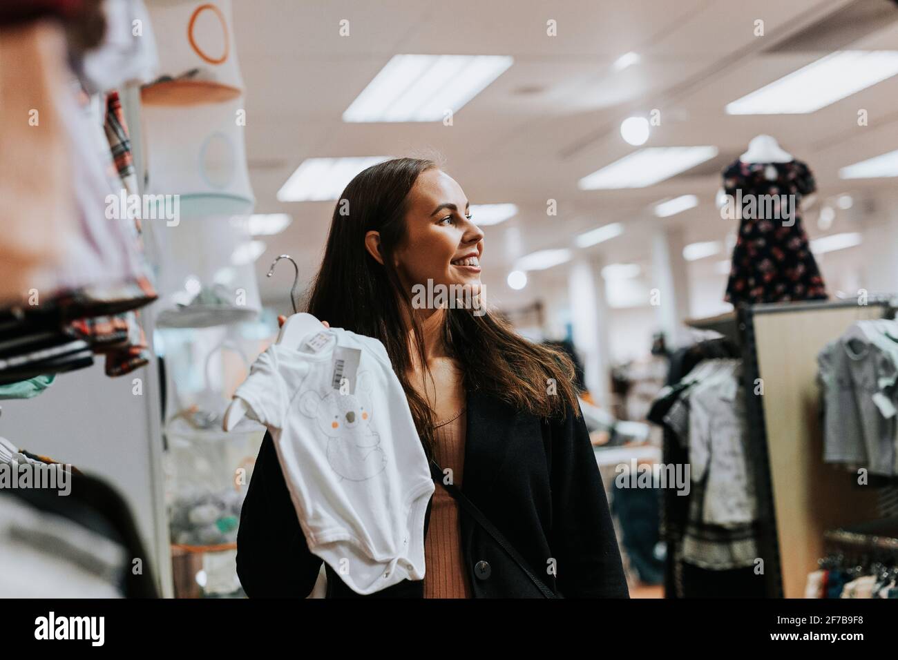 Donna sorridente nel negozio di abbigliamento Foto Stock