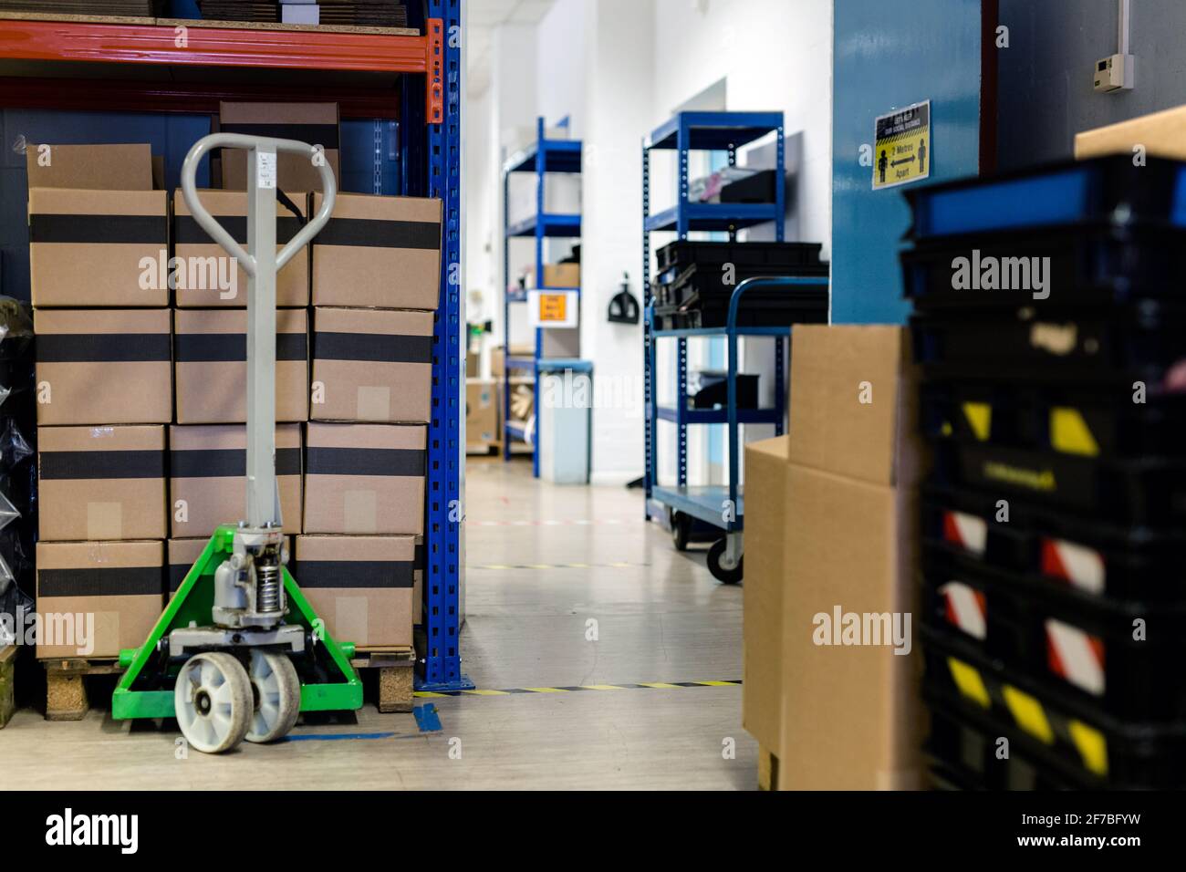 Pallet impilato con scatole pronte per la spedizione. Un transpallet è seduto sotto il pallet per essere pronto a spostarlo. Magazzino, spedizione, spedizione, parce Foto Stock