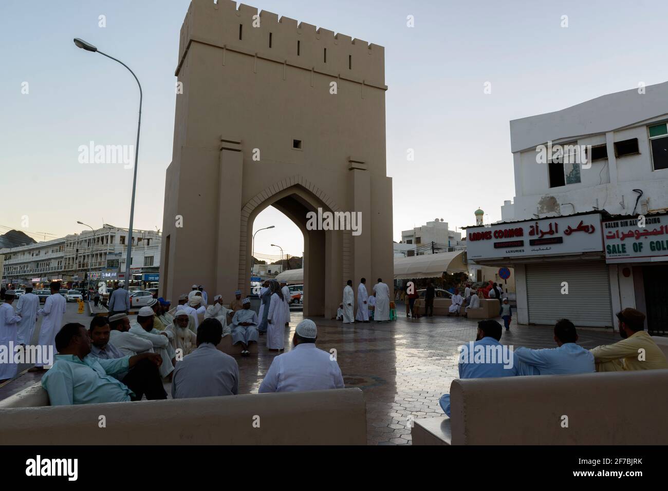 Gli uomini socializzano dopo una giornata calda nel centro della città di Mascate vicino al souk di Mutrah, Oman. Foto Stock