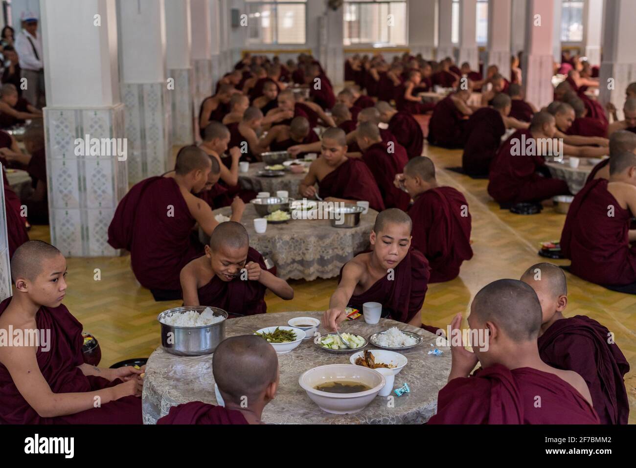 I monaci mangiano il pranzo al monastero KYA Khat a Bago, Myanmar Foto Stock