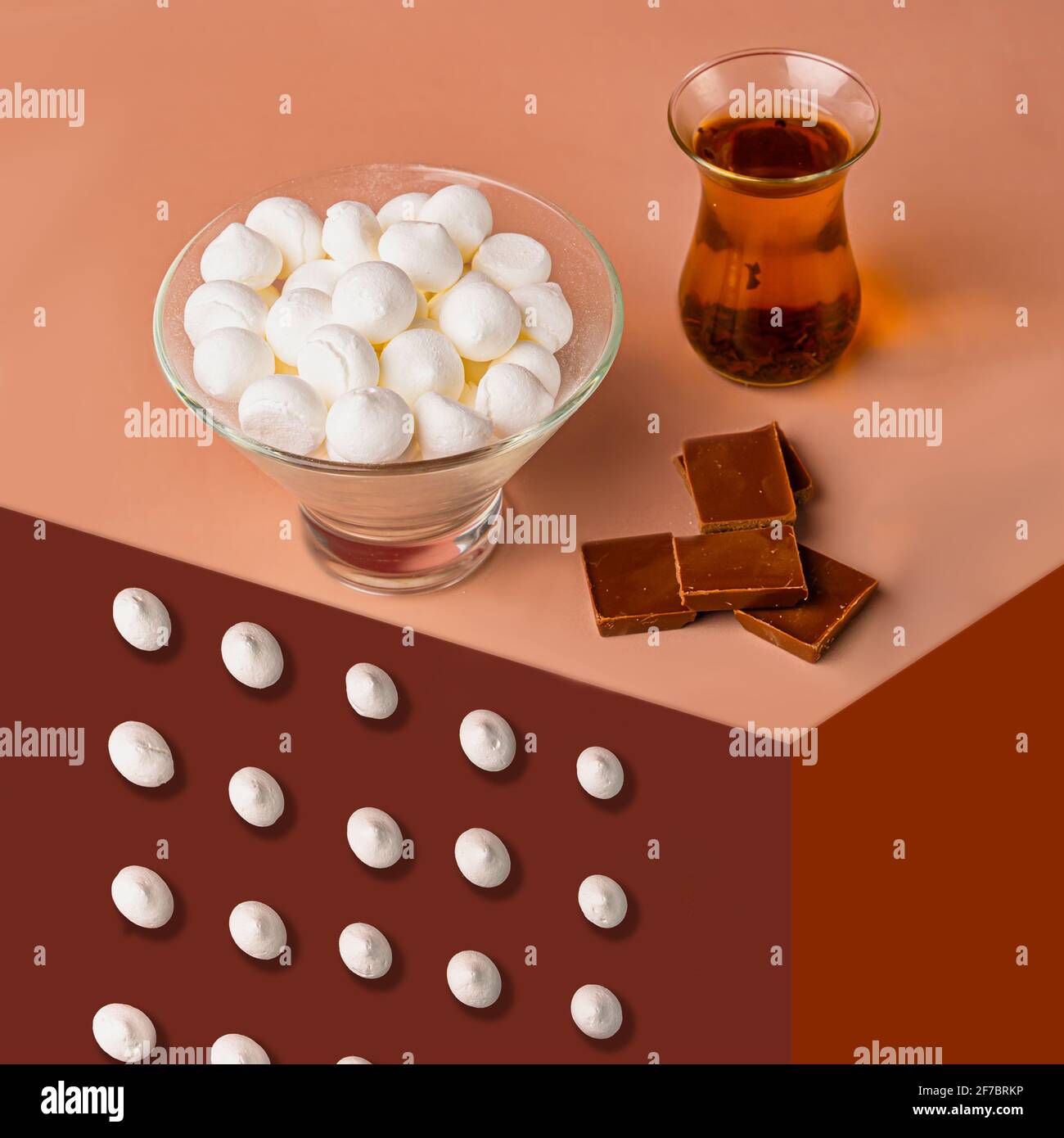 Meringa bianca in un piatto di vetro con tè nero. Foto Stock