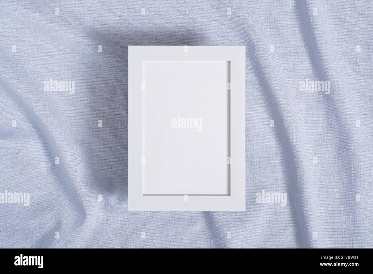 Cornice fotografica con mockup di carta bianca su neutro blu tessuto colorato Foto Stock