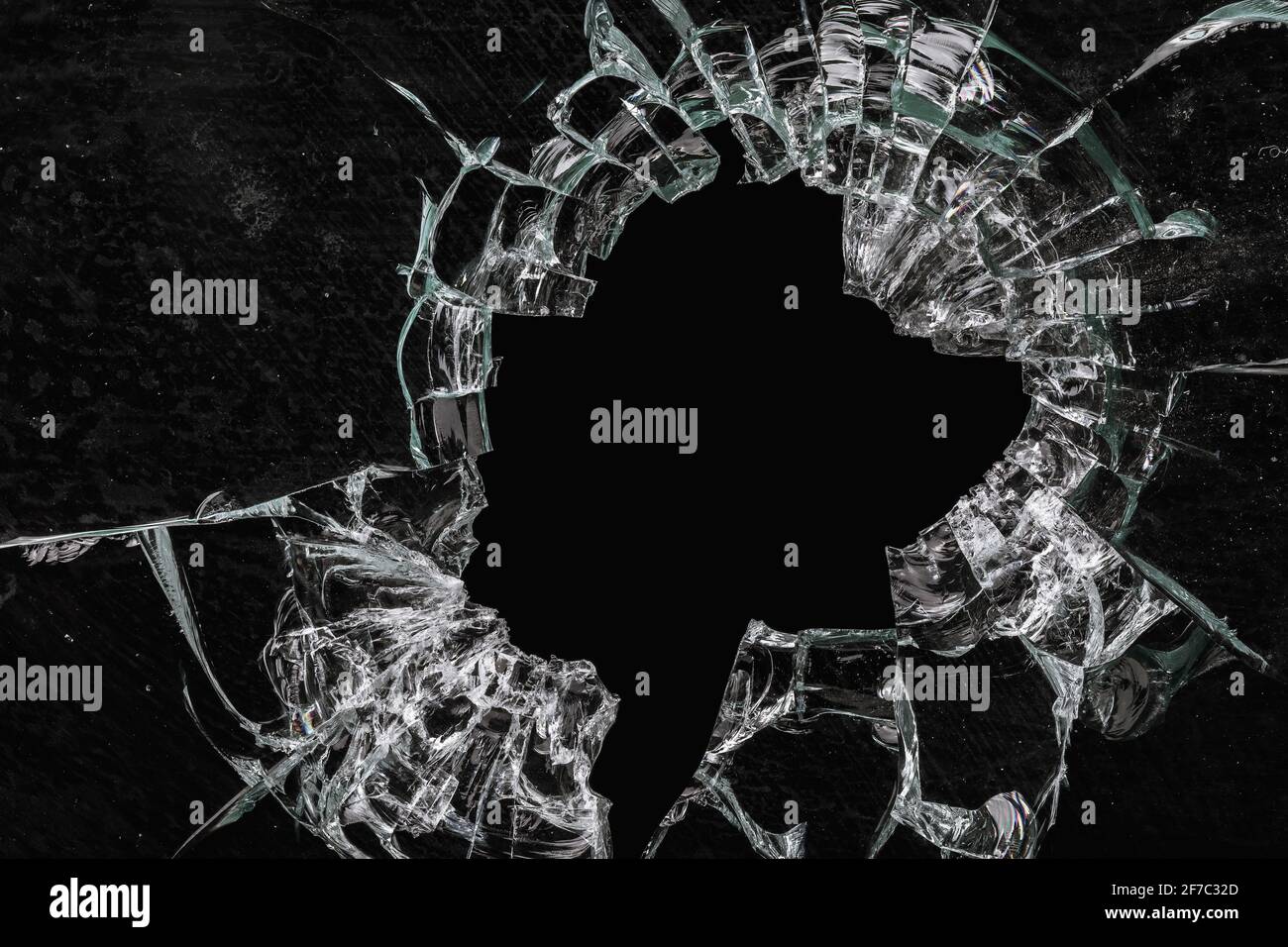 Un foro nel vetro sporco rotto su sfondo nero, primo piano Foto Stock