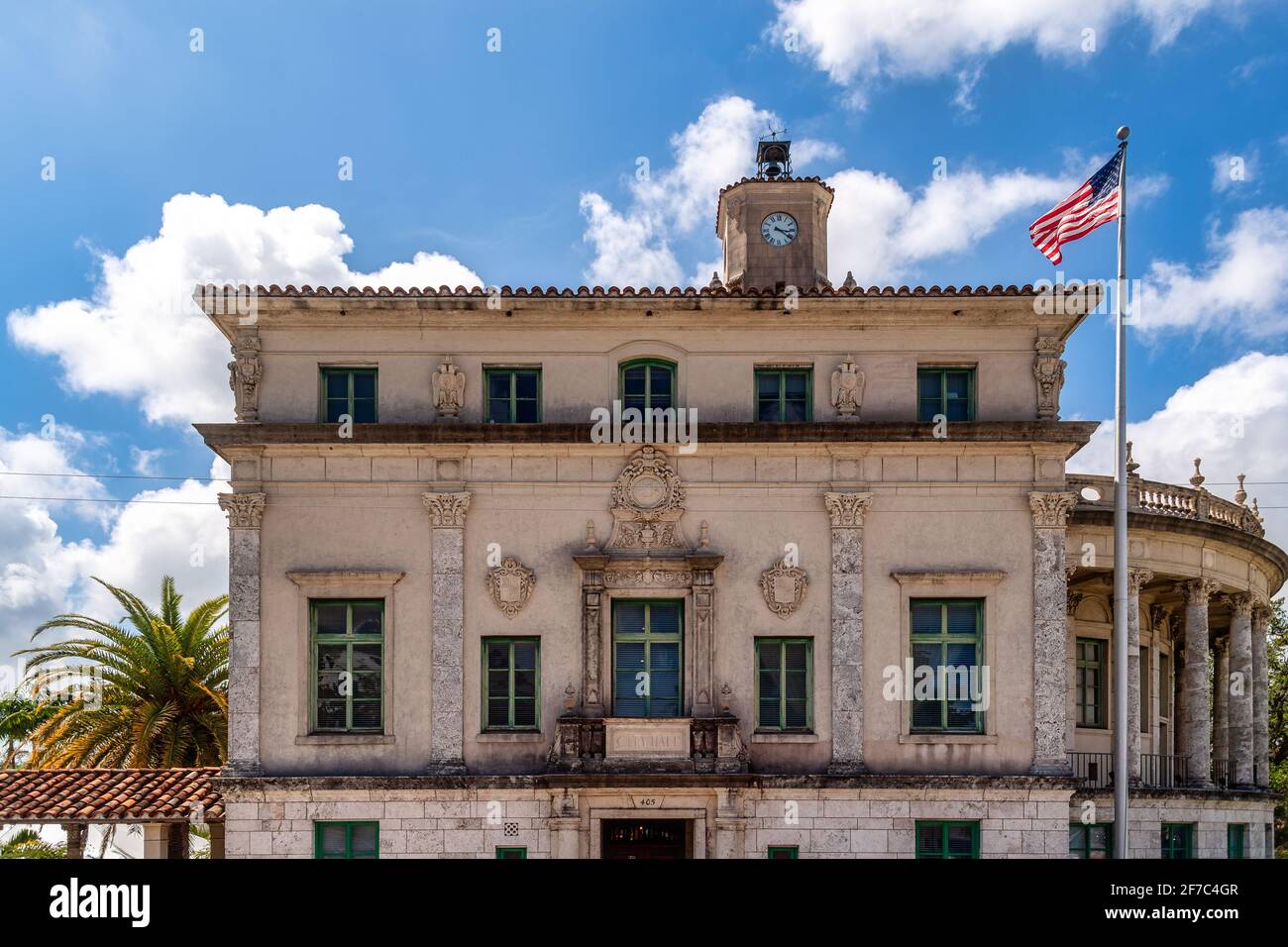 Edificio in stile mediterraneo con torre dell'orologio e bandiera americana, probabilmente il municipio di Coral Gables, Miami, Florida, Stati Uniti Foto Stock